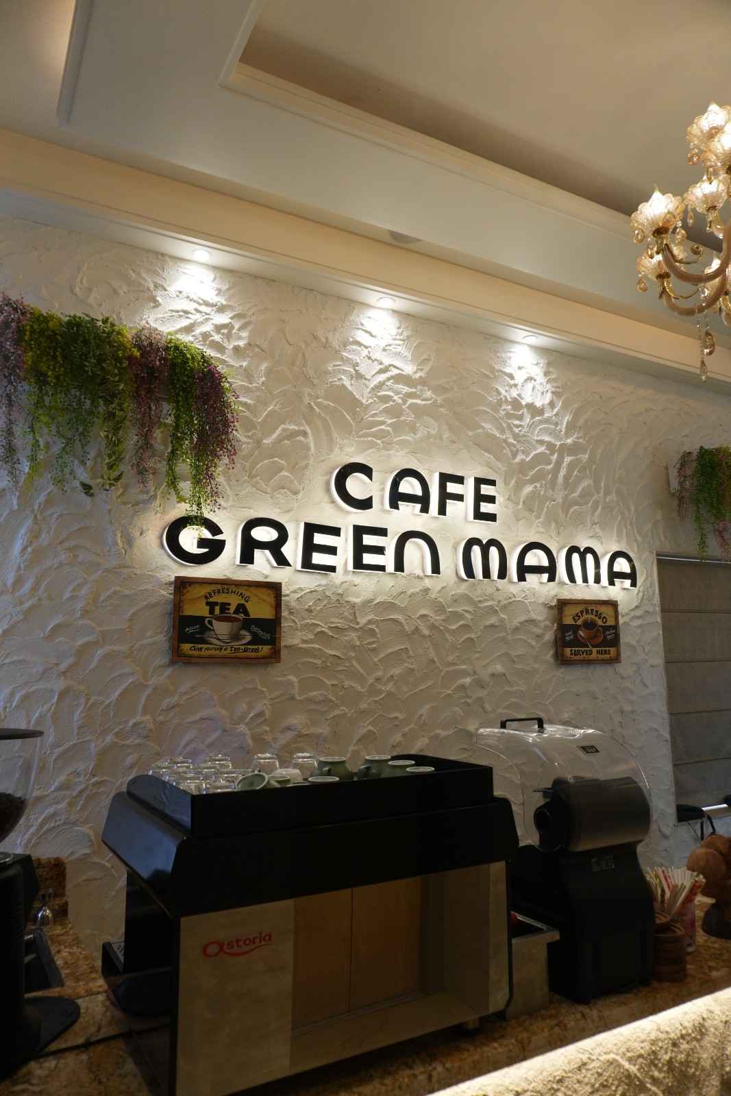 The counter and espresso bar beneath lettering reading Cafe Green Mama.