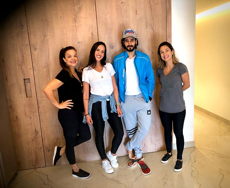 Four guests posing together against a wood-panelled wall.