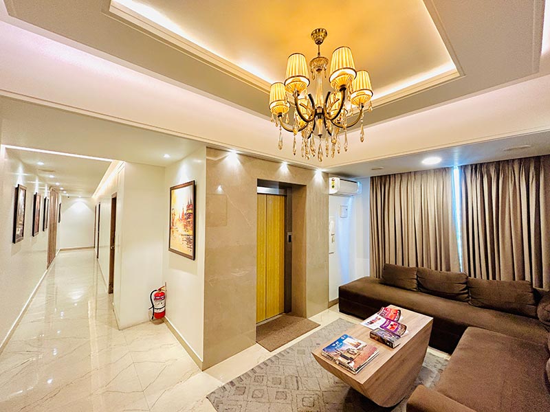 The lobby lounge with a chandelier, low sofas and warm downlighting.