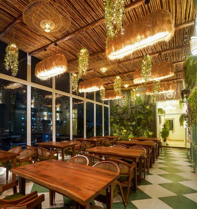 The Green Mama dining room with wooden tables and a wall of windows.