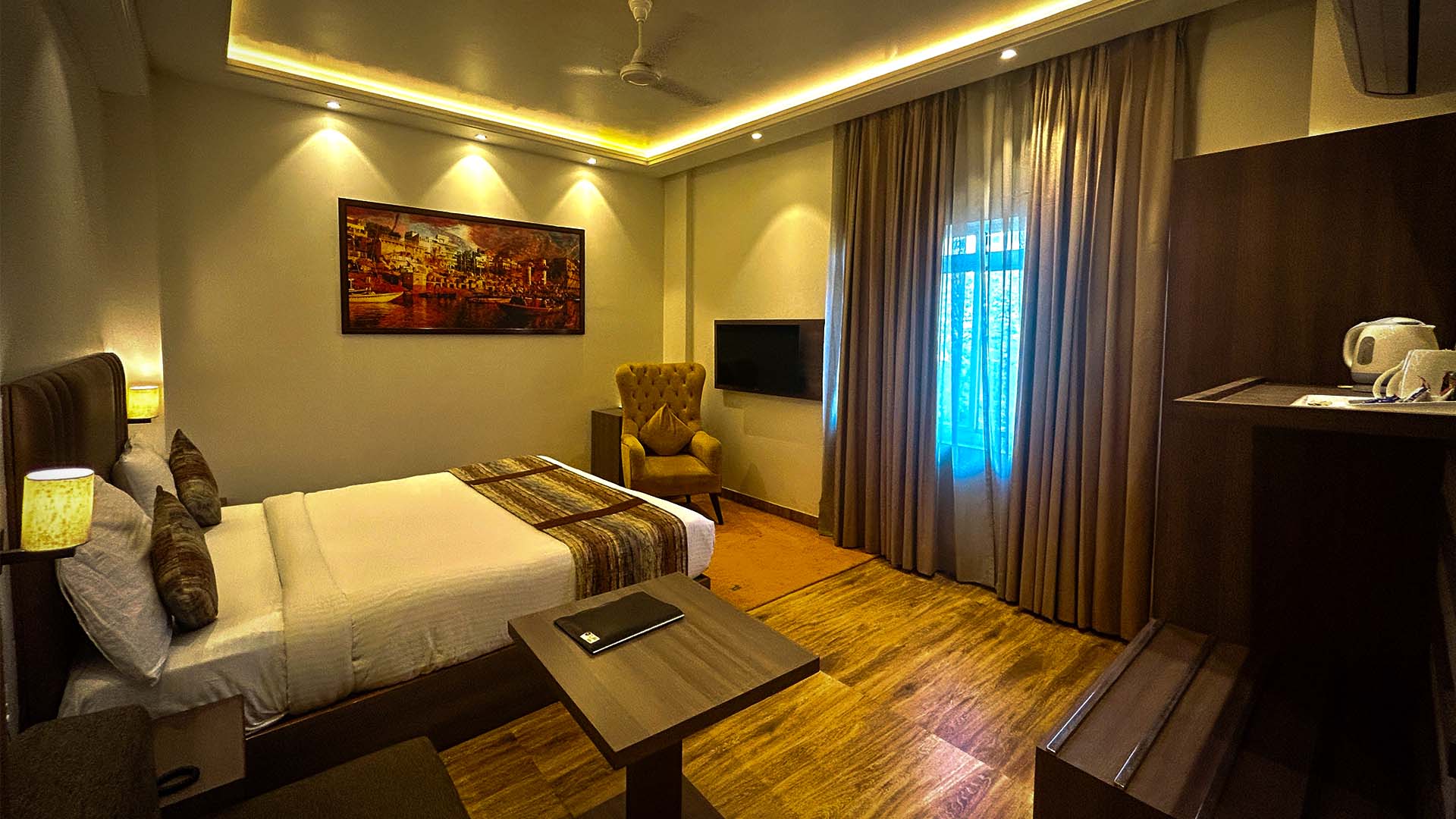 A king room with a large bed, armchair and wall-mounted television.