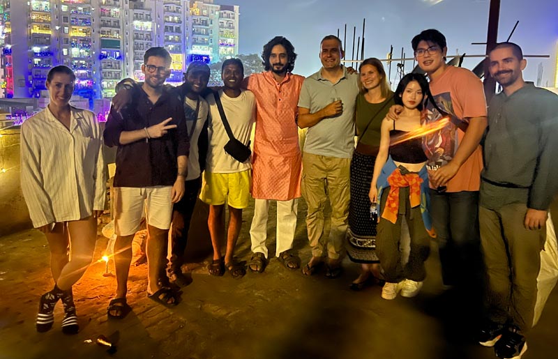 Hotel staff standing with a group of guests in the evening.