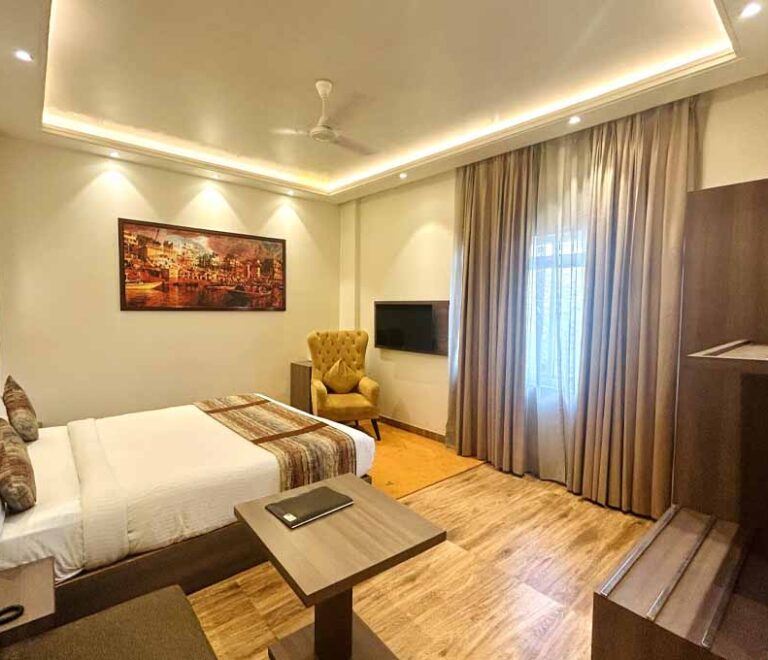 A guest room seen towards the window with curtains drawn back.